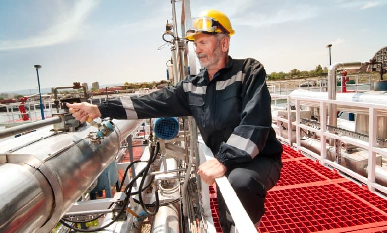 Travailleur de terrain à côté de gros tuyaux