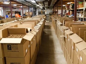 Entrepôt rempli de cartons de dons organisés pour la distribution communautaire