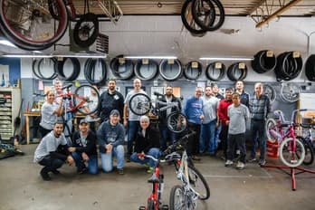 Équipe de bénévoles de Qualitrol avec des vélos réparés pour don.